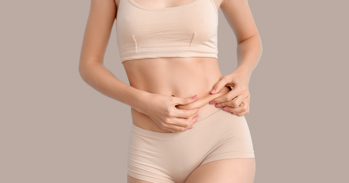 woman's body pinching her tummy with her two hands