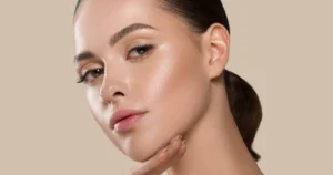 Young woman with smooth, lifted skin touching her jawline, showing results from PDO Threads in Las Vegas, NV